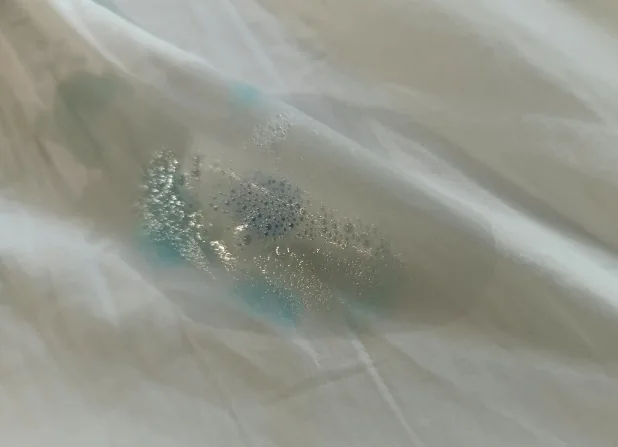 Aplicación del quitamanchas Microdor sobre la tinta azul de la sábana, foto real sin retocar